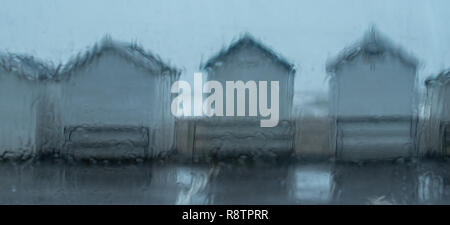 Lyme Regis, Dorset, UK. 18th December 2018.  UK Weather: A Wet and windy day at Lyme Regis.  Wet beach huts on Monmouth Beach as heavy downpours hit the coast at Lyme Regis.  A Yellow Warning of rain has been issued along the South West Coast. Credit: PQ Images/Alamy Live News Stock Photo