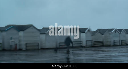 Lyme Regis, Dorset, UK. 18th December 2018.  UK Weather: A Wet and windy day at Lyme Regis.  Wet beach huts on Monmouth Beach as heavy downpours hit the coast at Lyme Regis.  A Yellow Warning of rain has been issued along the South West Coast. Credit: PQ Images/Alamy Live News Stock Photo