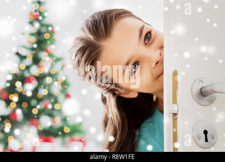 happy girl looking out open door on christmas Stock Photo