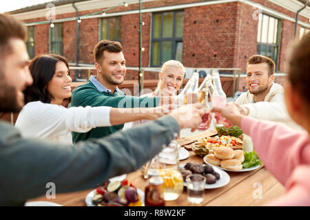 happy friends toasting drinks at rooftop party Stock Photo