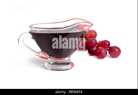 Balsamic vinegar in bowl with grape. Isolated on white background. Stock Photo