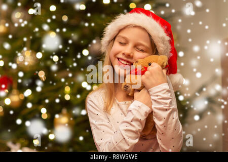smiling girl in santa hat with christmas gift Stock Photo