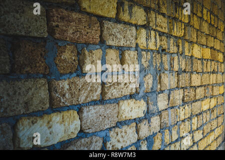 old wall of limestone with grey seams, perspective view Stock Photo