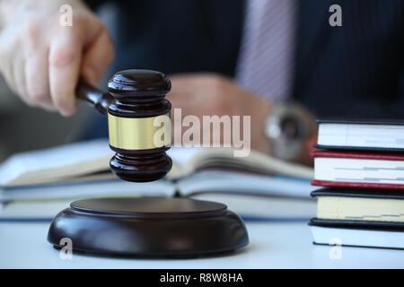 Judge holding hammer in hand lies Stock Photo