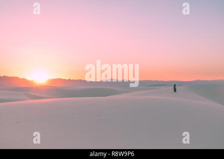 A girl watching a dramatic sunset in White Sands National Monument in New Mexico, USA Stock Photo