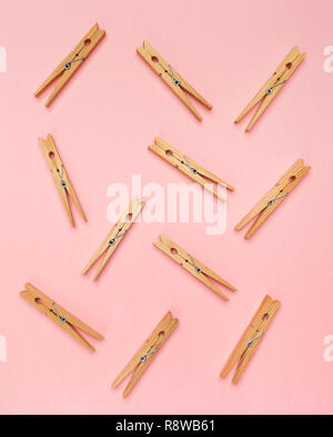 Wooden clothes pins on a pink background. Stock Photo