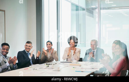 Happy, supportive business people clapping in conference room meeting Stock Photo