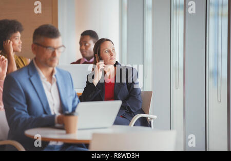 Thoughtful businesswoman looking out window in cafeteria Stock Photo