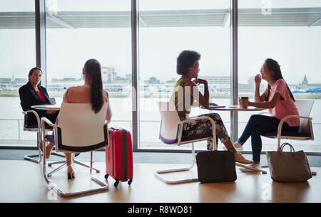 Businesswomen talking in airport business lounge Stock Photo