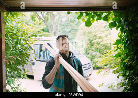 Portrait confident carpenter carrying equipment in garage Stock Photo