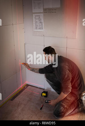 Construction worker using laser measuring tool Stock Photo