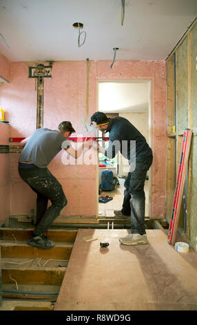 Construction workers using level tool in house Stock Photo