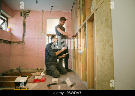 Construction workers framing inside of house Stock Photo