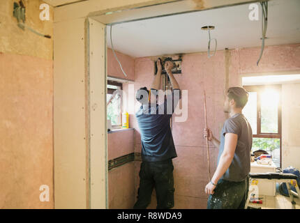 Construction workers installing copper pipe in house Stock Photo