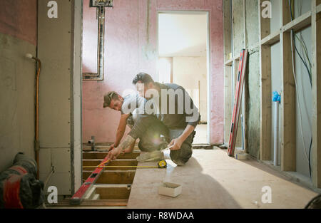 Construction workers using level tool in house Stock Photo