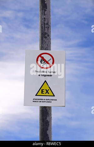 Sign next to a communications center in Portuguese. Translation: The sign above says 'MAKE NO SMOKING AND FIRE'; The sign below says 'EXPLOSIVE ATMOSP Stock Photo