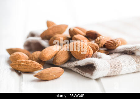 Dried almond nuts on checkered napkin. Unpeeled almonds. Stock Photo