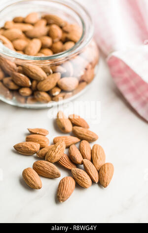 Dried almond nuts in jar. Unpeeled almonds. Stock Photo