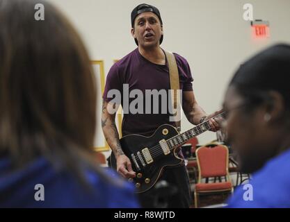 Former Korn guitarist and Rock to Recovery founder Wes Geer shouts pointers to Air Force Wounded Warrior Trials participants while playing the guitar during a Rock to Recovery practice session in Las Vegas, March 1, 2015. Geer played guitar during two interactive music sessions with AFW2 Trial’s band, and helped the group perform their song in front of family and friends during the games’ post-event banquet. Stock Photo