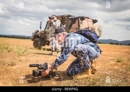 Royal Australian Air Force Sgt. Greg O’Neill, an imagery specialist with the Air Force Imagery Detachment, No. 28 Squadron, documents soldiers with the Australian and New Zealand Armies and Airmen with the U.S. Air Force, collect a high velocity combat deliver system, after an airdrop at Londonderry Drop Zone, near RAAF Richmond, Australia, March 13, 2017. The airdrop was part of the Advanced Tactics Aircrew Course, hosted by the Advanced Airlift Tactics Training Center, based out of St. Joseph Mo., which has the mission of increasing the war-fighting effectiveness and survivability of mobilit Stock Photo