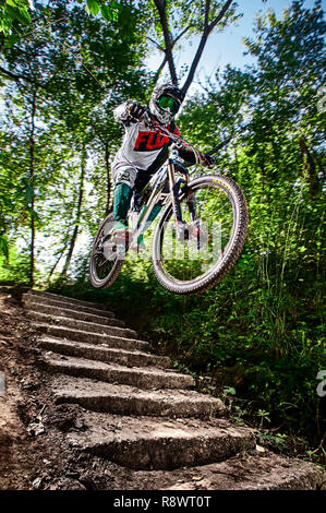 Moscow, Russia - August 31, 2017: Jump and fly on a mountain bike. Rider in action at mountain bike sport. Biker riding in forest. Cool athlete cyclis Stock Photo