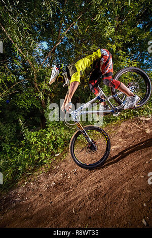 Moscow, Russia -  August 31, 2017: Mountain bike cyclist doing stoppie – ridden on the front wheel on a mtb bike. Biker riding extreme sport bicycle.  Stock Photo