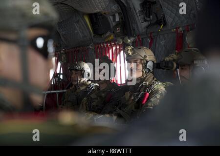 U.S. Marine Corps Staff Sgt. Xavier Ovando (left), Capt. Ben Skarzynski (center), and Sgt. Alexander Czub (right) wait to jump from U.S. Army CH-47 Chinook at Josari drop zone, Republic of Korea, March 17, 2017 as part of Korea Marine Exercise Program 17-6. KMEP is carried out in the spirit of the Republic of Korea-U.S. Mutual Defense Treaty signed between the two nations October 1, 1953. The Marines are with 3d Reconnaissance Battalion, 3rd Marine Division, III Marine Expeditionary Force. Ovando, a Los Angeles, California native, is the platoon sergeant. Skarzynski, is the platoon commander f Stock Photo