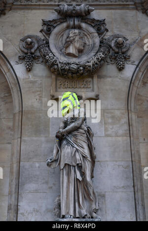 Protesters of Yellow Vests demonstration (Gilets Jaunes) against government, and French President put yellow vest and flag on Paris Opera Garnier Stock Photo