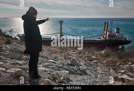 man looking at a cargo ship Stock Photo