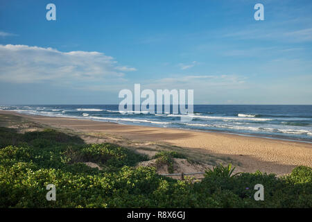 View of a beach with no people on the Australian coastline with a small amount of clouds in the sky Stock Photo