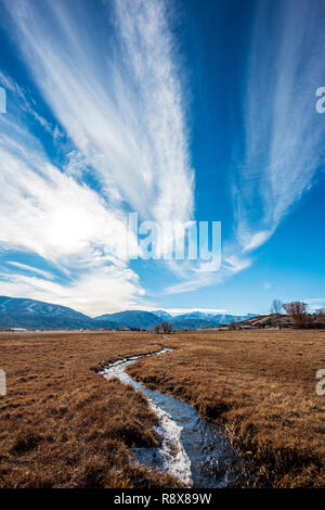 Ranch irrigation ditch & pasture; dramatic sky; Rocky Mountains; outside small town of Salida; Colorado; USA