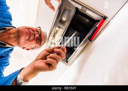 Mature male laboreris in the kitchen fixing the vent hood Stock Photo