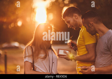 Three friends are outdoors argueing about directions in the park Stock Photo