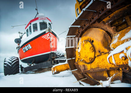 Tractor and Fishing Boats in the snow at Aldeburgh Suffolk England Stock Photo