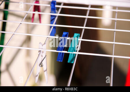 Cloth Clothespins on drying rack, selective focus. Colorful plastic clothespins on clothesline. A lot of multicolored wool cloth clamps attached. Stock Photo