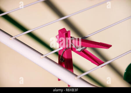 Cloth Clothespins on drying rack, selective focus. Colorful plastic clothespins on clothesline. A lot of multicolored wool cloth clamps attached. Stock Photo