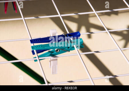 Cloth Clothespins on drying rack, selective focus. Colorful plastic clothespins on clothesline. A lot of multicolored wool cloth clamps attached. Stock Photo
