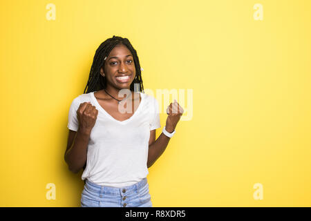 I won. Winning success happy woman celebrating being a winner. Dynamic image of female model on yellow studio background. Victory, delight concept. Hu Stock Photo