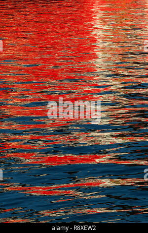 Reflections from a ship throwing interesting patterns on the water Mirror image on water. Stock Photo