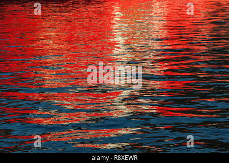 Reflections from a ship throwing interesting patterns on the water Mirror image on water. Stock Photo