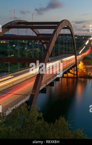 A busy flow of traffic crosses the iconic Pennybacker Bridge, known by locals as the 360 Bridge, in the hill country of the Texas capital of Austin Stock Photo