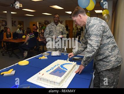 Col. C. Mike Smith, 81st Training Wing vice commander, cuts a cake during the Air Force Aid Society 75th Anniversary Celebration at the Sablich Center March 10, 2017, on Keesler Air Force Base, Miss. Gen. Henry ‘Hap’ Arnold founded the relief organization in 1942, which is the official charity of the U.S. Air Force and exists to meet the unique needs of Total Force Airmen, their families and widows or widowers. Stock Photo