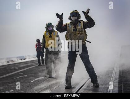 WATERS EAST OF THE KOREAN PENINSULA (March 12, 2017) Sailors participate in flight operations on the flight deck of the aircraft carrier USS Carl Vinson (CVN 70). The ship and its carrier strike group are on a western Pacific deployment as part of the U.S. Pacific Fleet-led initiative to extend the command and control functions of U.S. 3rd Fleet. Stock Photo