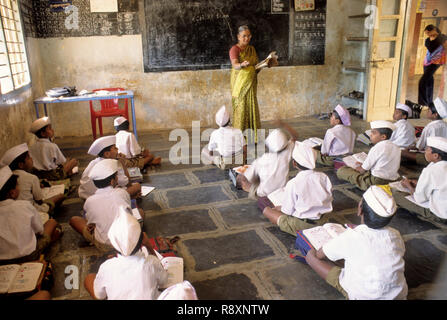 Lady Teacher teaching school children in classroom, sangli, maharashtra, india