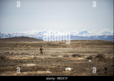 Tech. Sgt. Ben Domain, a Survival, Evasion, Resistance, and Escape (SERE) specialists with the 308th Rescue Squadron, checks wind direction on a landing zone for pararescuemen parachuting out of a HC-130J Combat King II, March 2, 2017, at the Orchard Combat Training Center in Idaho, during pre-deployment training for the 305th Rescue Squadron. The 305th RQS, located at Davis-Monthan Air Force Base, Ariz., is conducting training at the Idaho Air National Guard’s Orchard Combat Training Center, a 143,000-acre live-fire range located south of Boise, Idaho, to hone all of their search and rescue p Stock Photo