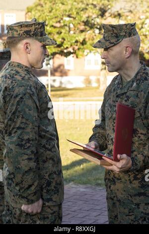 U.S. Marine Sgt. Christopher M. Casilio, left, a reconnaissance Marine with Headquarters and Services Company, 2nd Reconnaissance Battalion, 2nd Marine Division (MARDIV), is given the Senior Non-Commissioned Officer of the Quarter Award by Col. David L. Odom, assistant division commander of 2nd MARDIV, during a morning colors and awards ceremony on Camp Lejeune, N.C., Dec. 6, 2018. The ceremony is conducted once a quarter to honor colors as well as recognize Marines and Sailors for their accomplishments while serving. Stock Photo