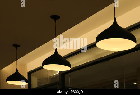 Three ceiling pendant lampshades lighting up the warm light Stock Photo