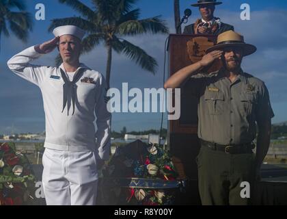 PEARL HARBOR (Dec. 7, 2018) Yeoman 1st Class Frank Mulvaney, left, and National Park Service Ranger Jason Ockrassa deliver a wreath symbolizing the U.S. Navy's contributions to Pearl Harbor during the attacks on Dec. 7th, 1941 during the National Pearl Harbor Remembrance Day 77th Anniversary ceremony. The ceremony was held in remembrance of the 2,390 American casualties lost during the attack on Pearl Harbor and to reflect on the peace and prosperity forged by all who fought on. Stock Photo