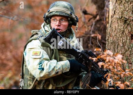 A member of the Albanian armed forces relays information to his team during a training exercise as part of exercise Combined Resolve XI in Hohenfels Training Area, Germany, Dec. 7, 2018.    CBRXI gives the U.S. Army’s regionally allocated forces in Europe the opportunity to execute a combat training center rotation with a joint, multinational environment demonstrating their integration into U.S. Army Europe operations. Stock Photo