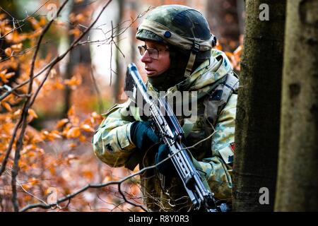 A member of the Albanian armed forces communicates with his team during a training mission as part of exercise Combined Resolve XI in Hohenfels Training Area, Germany, Dec. 7, 2018.  CBRXI gives the U.S. Army’s regionally allocated forces in Europe the opportunity to execute a combat training center rotation with a joint, multinational environment demonstrating their integration into U.S. Army Europe operations. Stock Photo